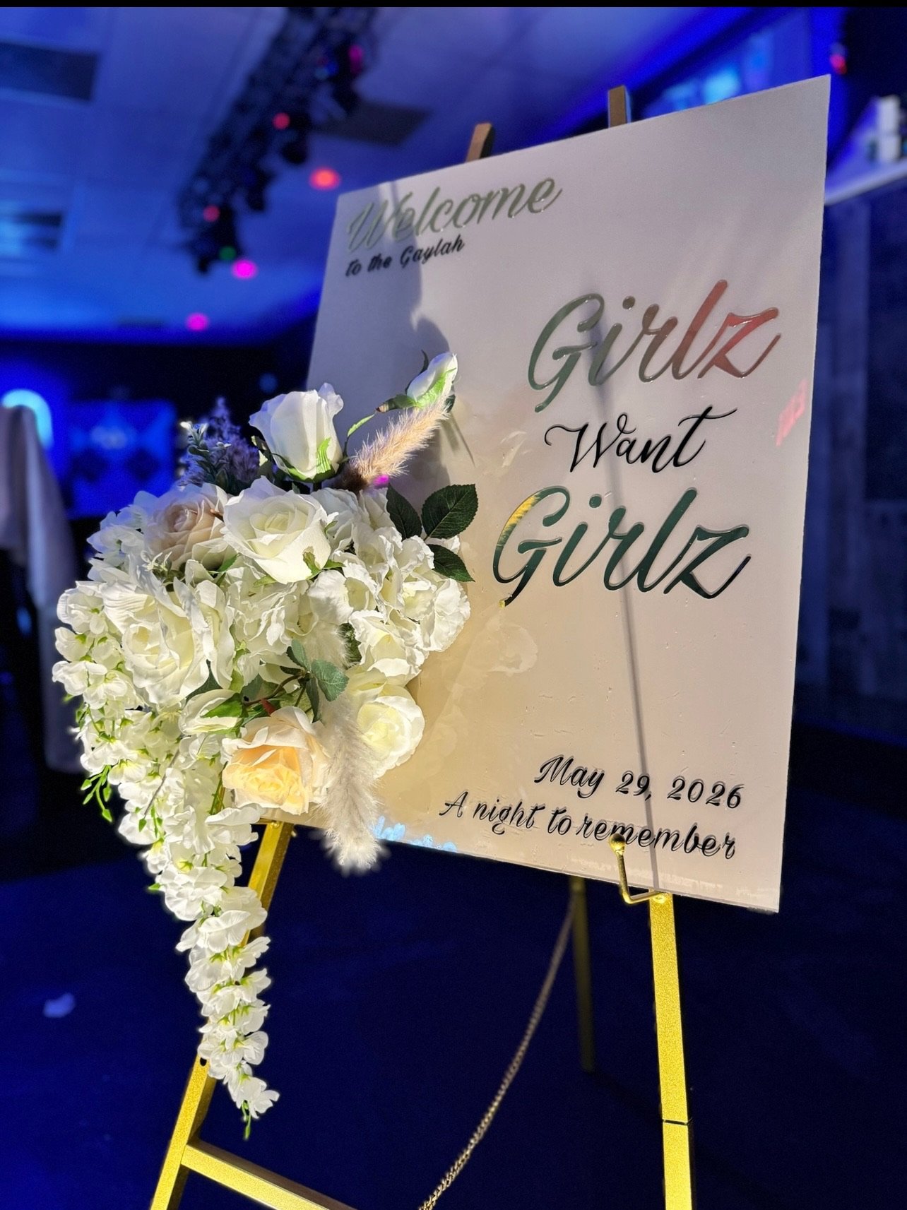 Welcome easel sign with a cascading white floral arrangement
