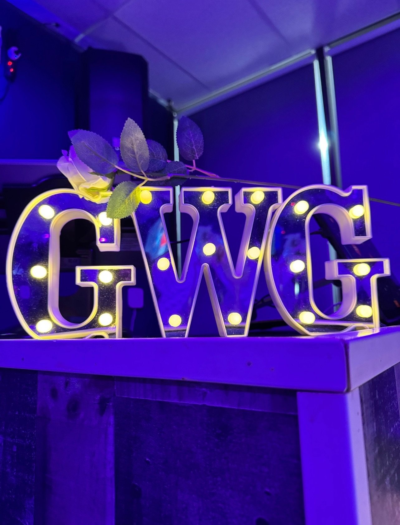 Illuminated GWG marquee letters with a white rose