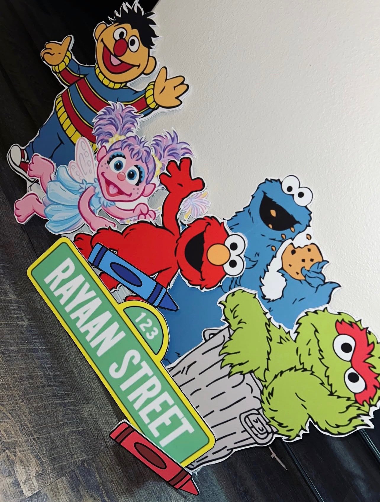 Character cutouts and a custom street sign for a first birthday